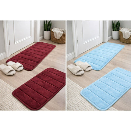 Two sets of red and blue bath mats on a wooden floor with slippers.