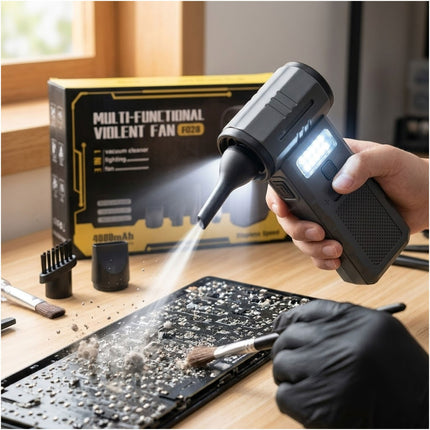 Person using a multi-functional violent fan to clean a laptop screen with a box in the background.