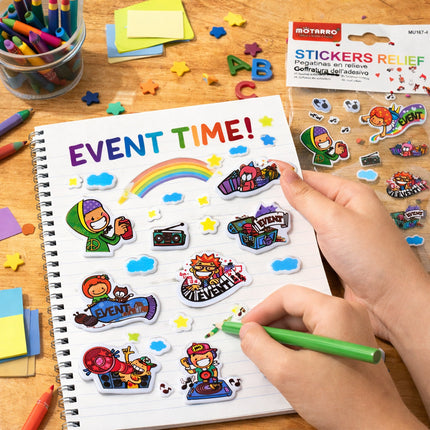 Children's notebook with stickers and a hand holding a green pen on a wooden table.