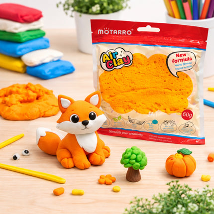 Mоторро Air Clay packaging with a fox sculpture and other clay creations on a wooden surface.