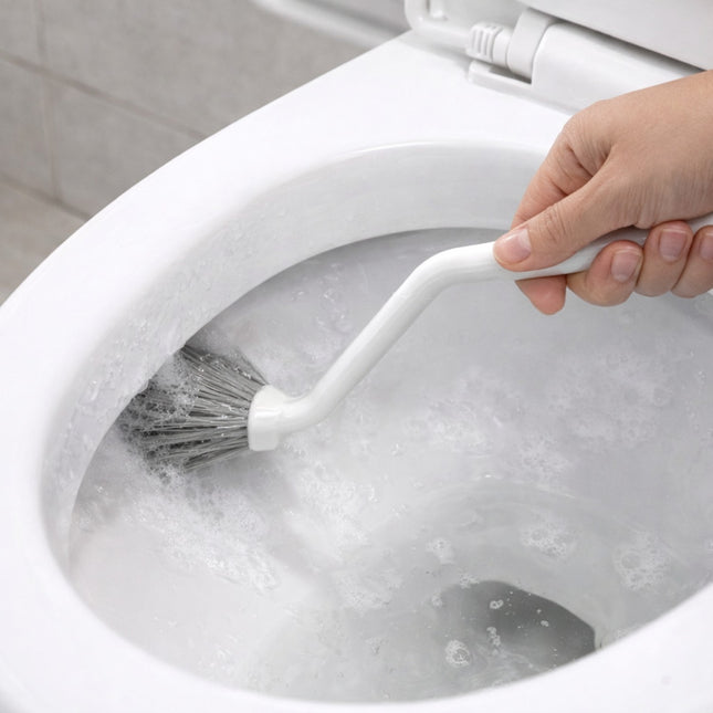 Person cleaning a toilet bowl with a brush