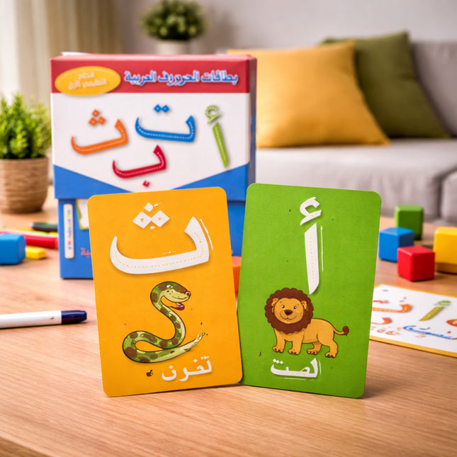 Colorful educational cards with Arabic letters and illustrations on a wooden table.
