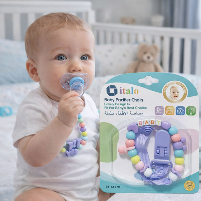 Baby holding a pacifier with a colorful teether chain, next to its packaging.