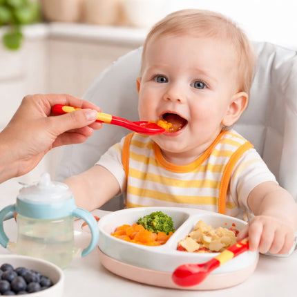 Baby being fed with a spoon, sitting in a high chair with a bowl of food in front.