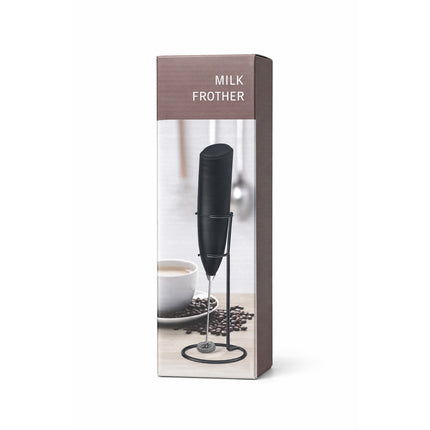 Milk frother in packaging with a cup and coffee beans on a white background