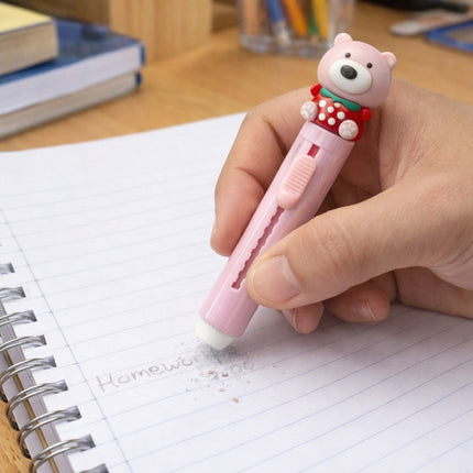Person holding a pink bear-shaped pen over a notebook