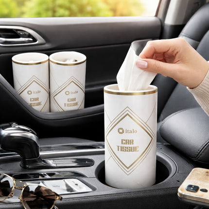 Person using italo car tissue in a car's cup holder with sunglasses and phone on the dashboard.