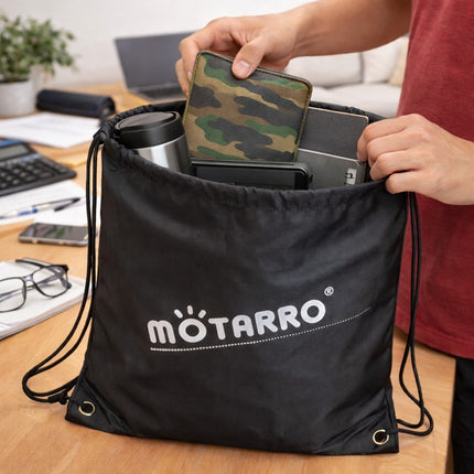 Person organizing items into a black drawstring bag with 'motarro' branding on a desk.