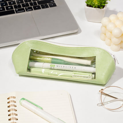 Green pencil case with pens on a desk next to a laptop