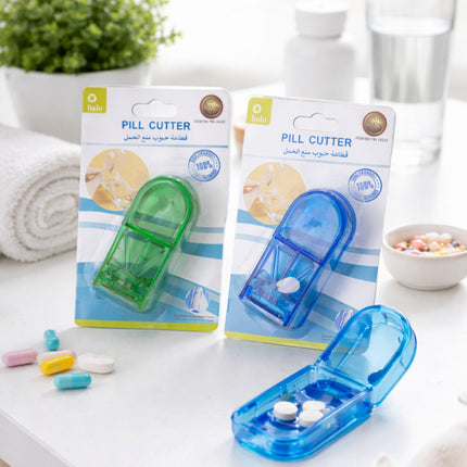 Two packages of a pill cutter with a blue and green device on a white surface.