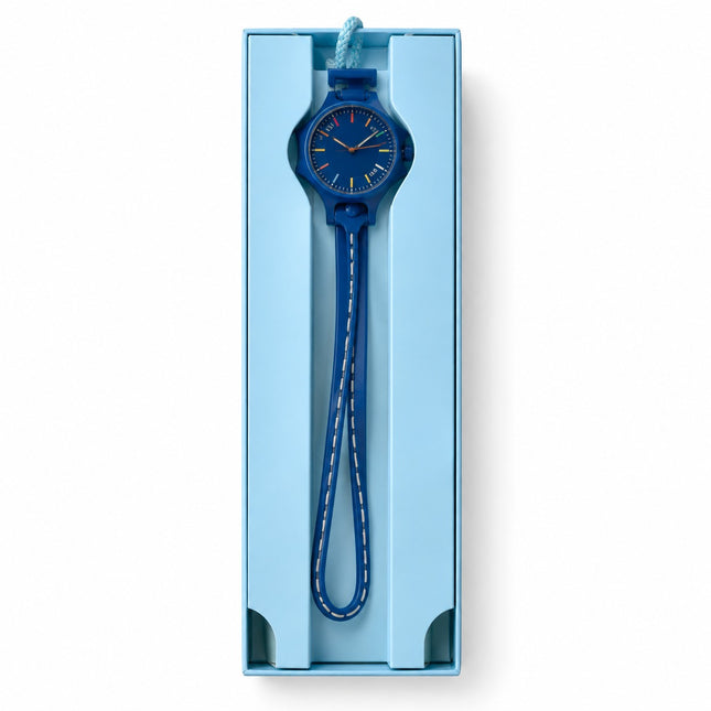 A blue analog wristwatch with a matching blue strap and white stitching, presented inside a light blue rectangular gift box on a white background.