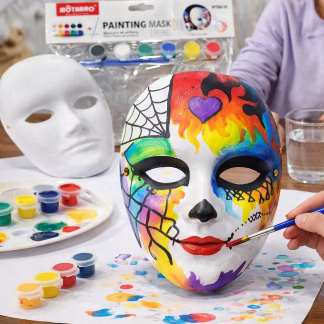 Colorful mask being painted with art supplies on a table