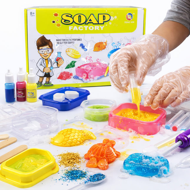 Soap-making kit with colorful soap molds and ingredients, featuring a 'Soap Factory' box.