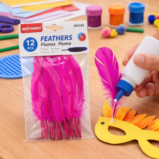 Pink feathers with glue being applied to a craft project on a wooden surface.
