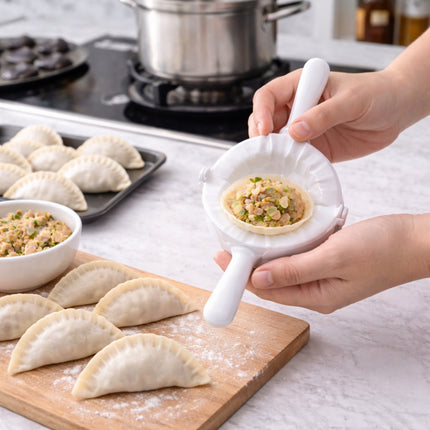 Person using a white dough press to make dumplings on a kitchen counter.