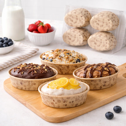 Assorted baked goods on a wooden board with berries and milk in the background