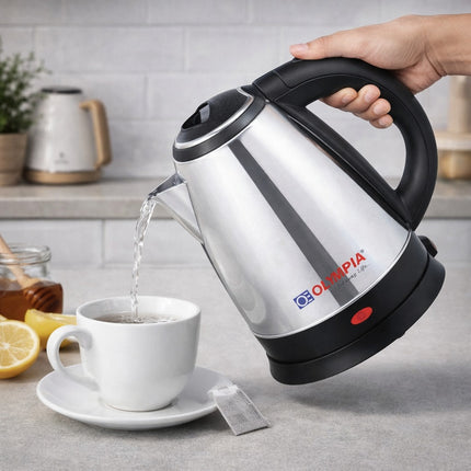 Olympia electric kettle being used to pour water into a white mug on a kitchen counter.