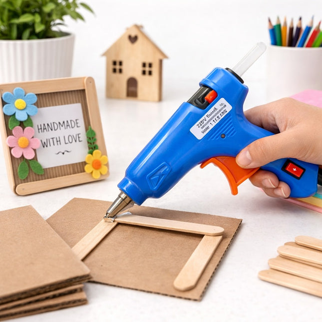 Hot glue gun being used on craft materials with a 'Handmade with Love' sign in the background.