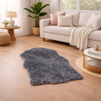 Living room with a gray rug on wooden floor, beige sofa, and decorative items.