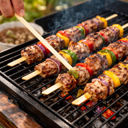 Skewers with meat and vegetables being grilled on a barbecue