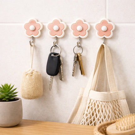 Flower-shaped hooks on a wall with keys, a bag, and a small pouch.