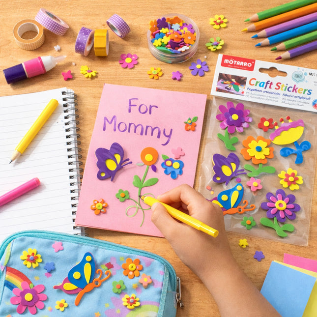 Children's craft activity with stickers, markers, and a notebook on a wooden table.