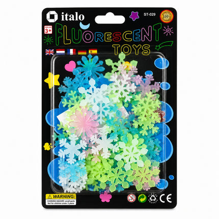 A retail package of Italo brand fluorescent snowflake toys. The black blister card features colorful text and graphics, including the 'italo' brand logo, and contains a clear plastic window showing a pile of multicolored, glowing plastic snowflakes in shades of blue, green, pink, and white.