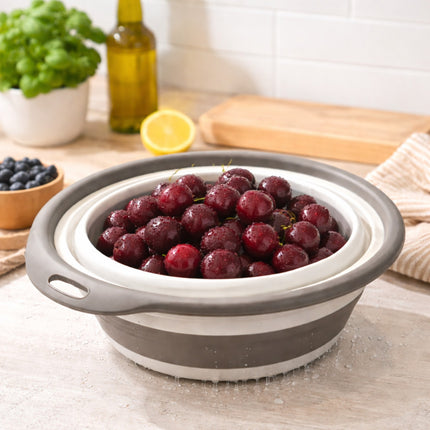 Collapsible silicone bowl with grapes on a kitchen counter