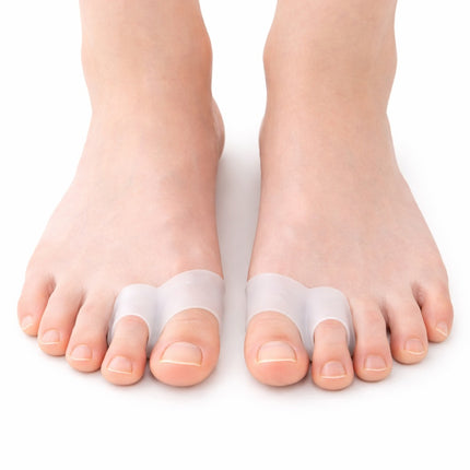 Two feet wearing toe separators on a white background