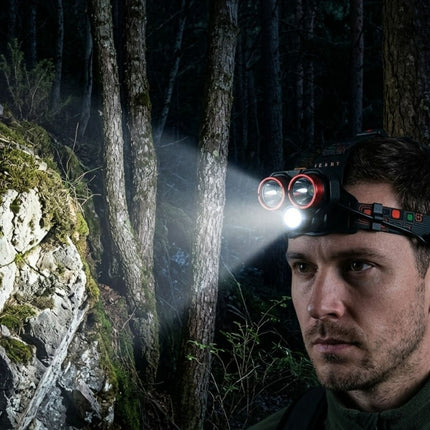 Man with a headlamp exploring a dark forest