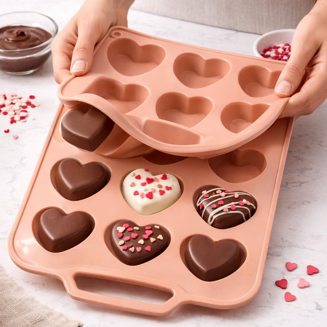 Heart-shaped silicone mold with chocolate treats on a light surface