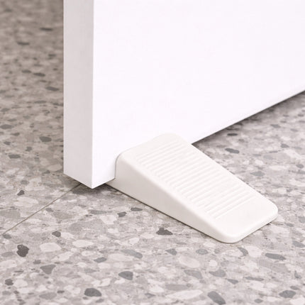 White wedge-shaped object on a textured gray floor