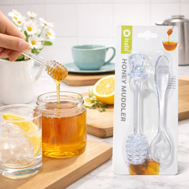 Honey being drizzled into a glass with a honey muddler and packaging in the background.