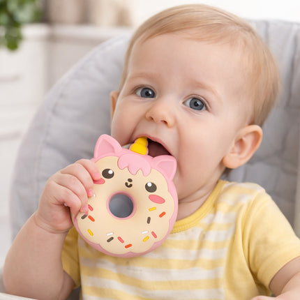 Baby holding a donut-shaped toy with sprinkles and a face