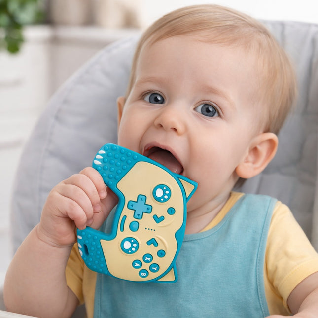 Baby holding a blue and beige teething toy with a neutral background