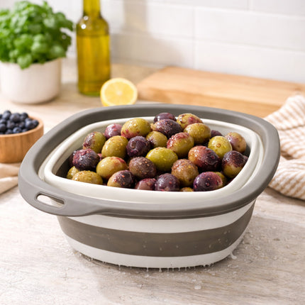 Collapsible colander with grapes on a kitchen counter