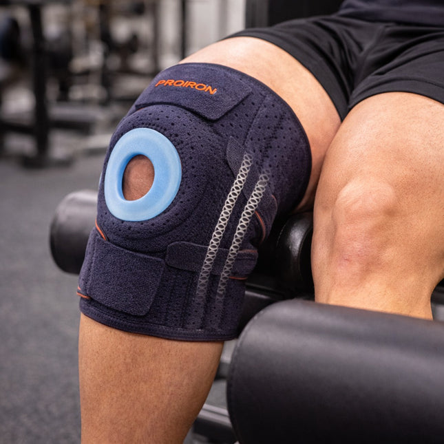 Person wearing a knee brace with 'ProIron' branding in a gym setting
