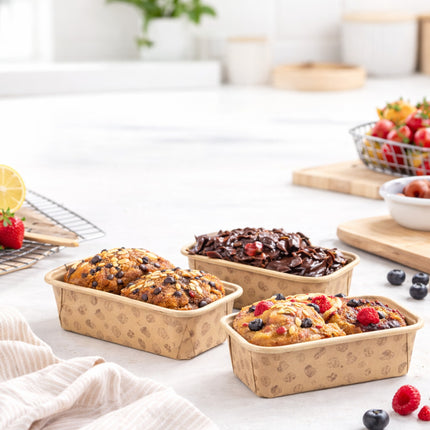 Three rectangular baking trays with different types of baked goods on a kitchen counter.