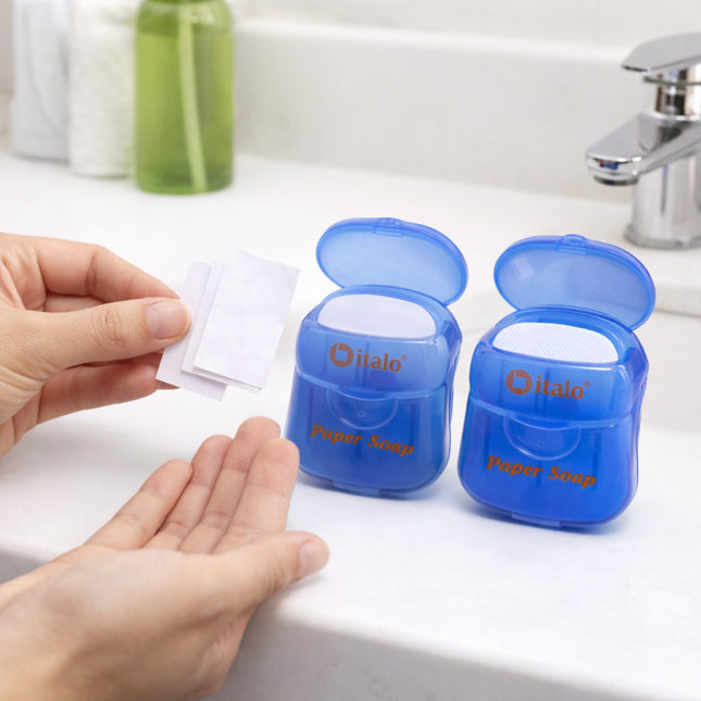 Two blue 'Halo' paper soap containers on a bathroom counter with a hand reaching for a sheet.