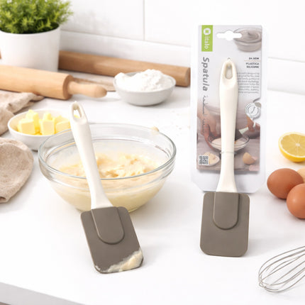 Silicone spatulas on a kitchen counter with baking ingredients and tools.