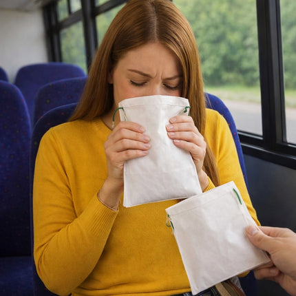 Woman on a bus holding tissues to her nose, possibly due to a cold or allergy.