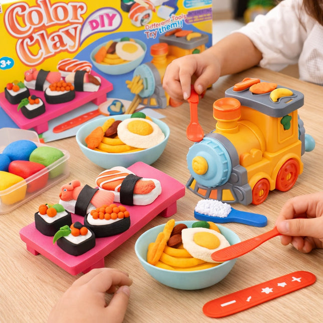 Children playing with toy food and train set on a table, with 'Color Clay DIY' packaging in the background.