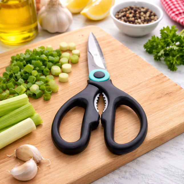 Black kitchen shears on a wooden cutting board with chopped vegetables and seasonings.