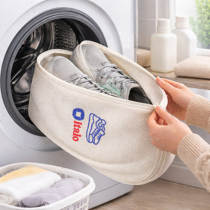 Person holding a shoe bag with a logo in front of a washing machine