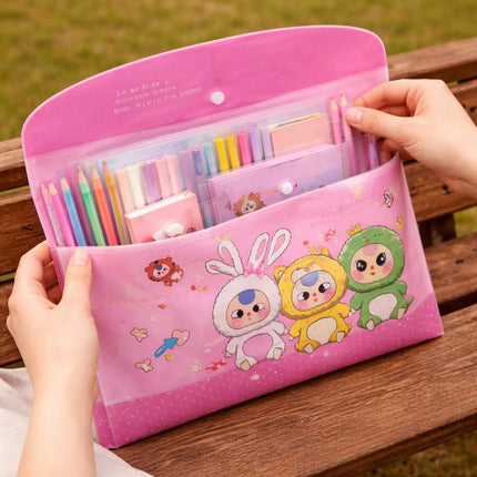 Pink stationery set with cartoon characters on a wooden surface