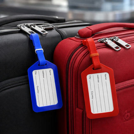 Two suitcases, one black and one red, with blue and red luggage tags attached.