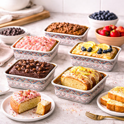 Assorted baked goods in patterned containers on a table with fruits and pastries.