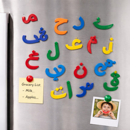 Colorful magnetic letters on a refrigerator with a grocery list and photo attached