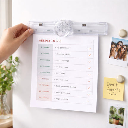 Hand holding a clear plastic holder with a 'Weedly To Do' list on a white surface with decorative items.