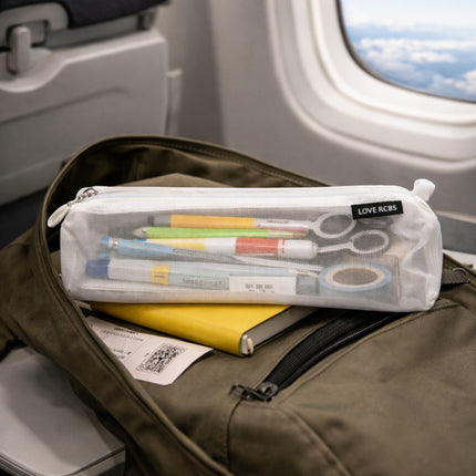 Pencil case with stationery items on a seat in an airplane